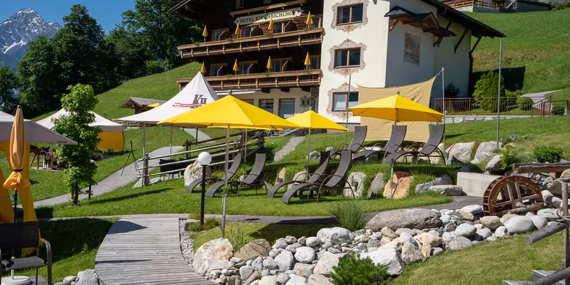 Außenaufnahme des Hotel Kirchbichlhof in Hippach im Zillertal mit Liegewiese im Sommer